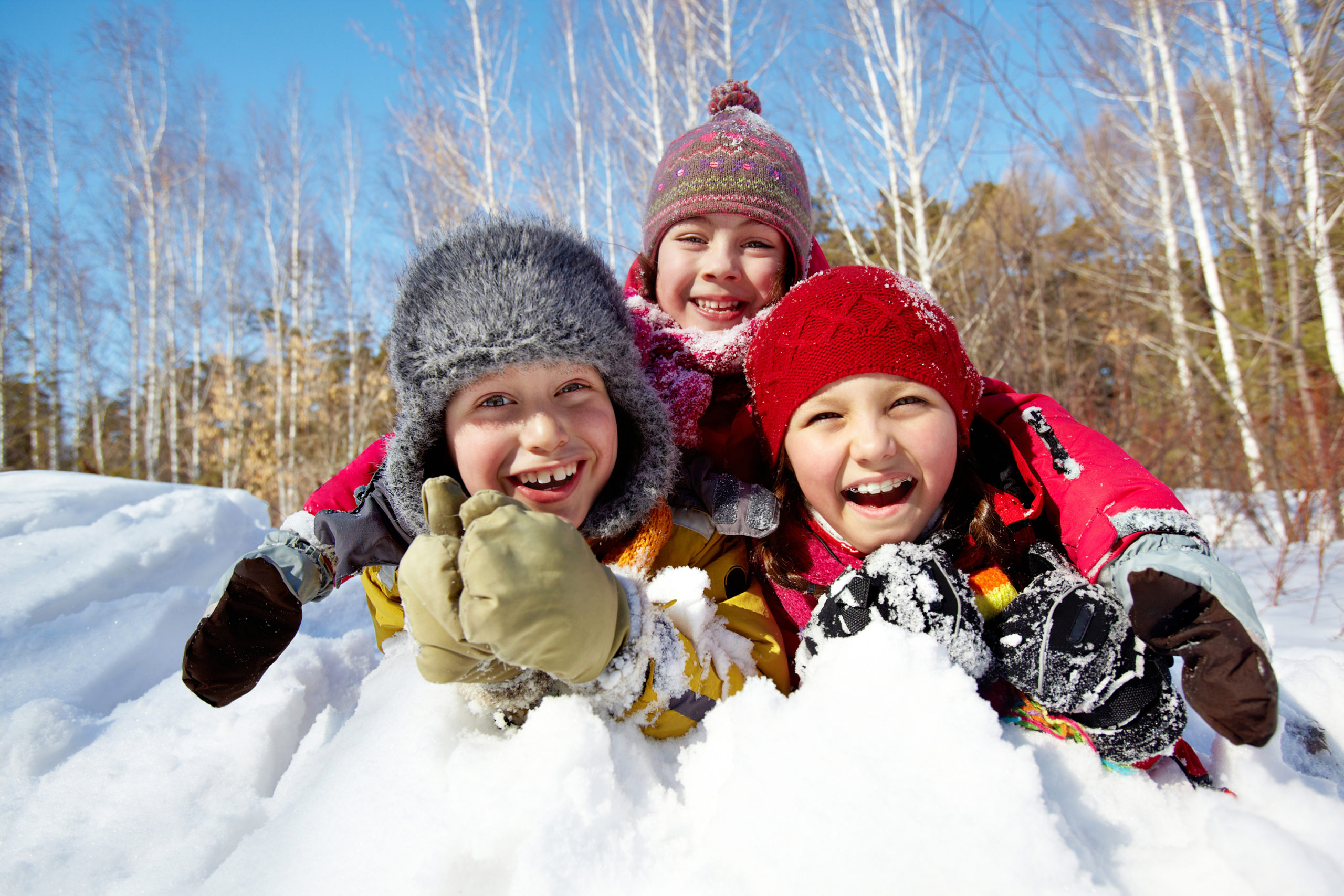 3 kids in snow pile laughing